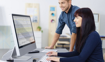 junges team schaut auf eine tabelle am pc